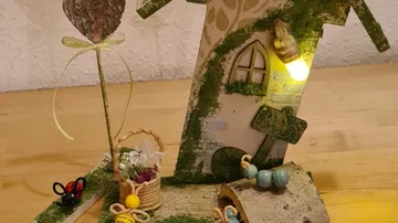 Decorative fairy house with light and flowers.