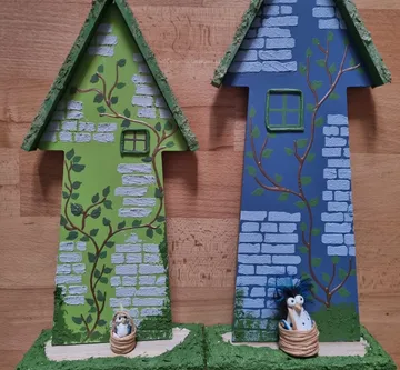 Zwei bemalte Vogelhäuschen mit Backsteinmotiven.