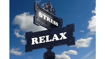 Signpost with 'Stress' and 'Relax' words under blue sky.
