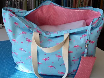 Blue bag with flamingos, opened, empty inside.