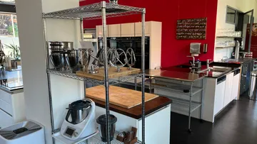 Modern kitchen with mixers and shelves.