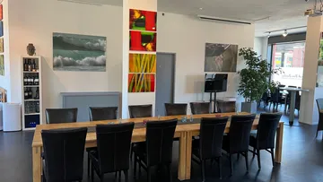 Dining room with long table, art on walls.