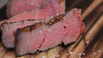 Geschnittenes mittelseltenes Steak auf Holzbrett.