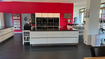Moderner Küchenausstellungsraum mit roten Wänden.
