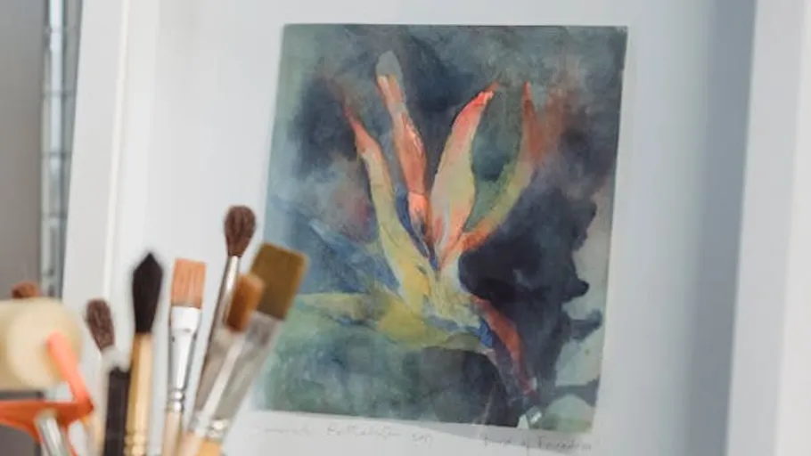 Abstract painting with brushes in foreground.