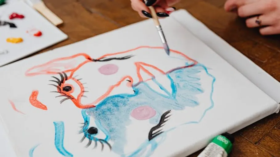 Person, die abstrakte Gesichter auf Leinwand malt.