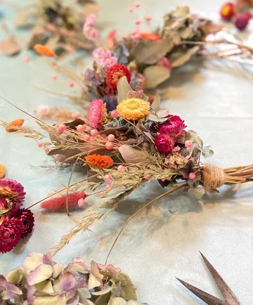 Colorful dried flower wreath on table.