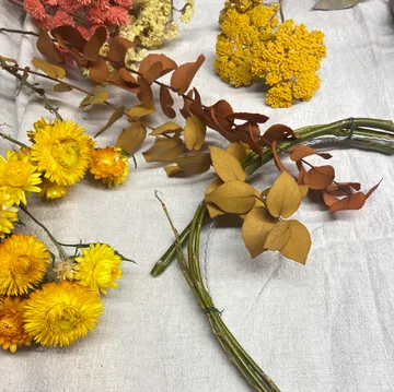 Dried flowers and foliage on a tablecloth.