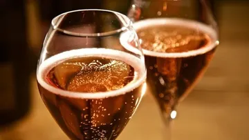 Two glasses of bubbling rosé champagne.
