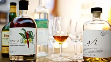 Rumflaschen und Gläser auf einem Holztisch.