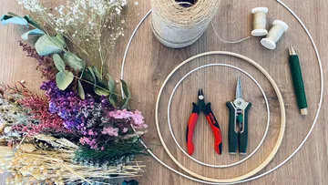 Florist tools, wire hoops, dried flowers on table.