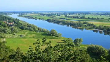 Fluss schlängelt sich durch eine üppige grüne Landschaft.