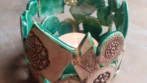 Decorative candle holder with teal designs.