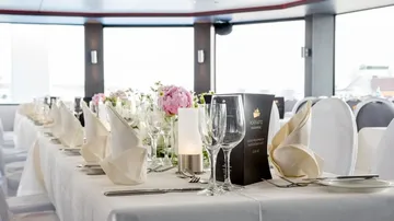 Elegant table covered with glasses and flower arrangement
