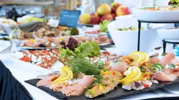 Fish dishes on a buffet, deliciously prepared, with fruit.