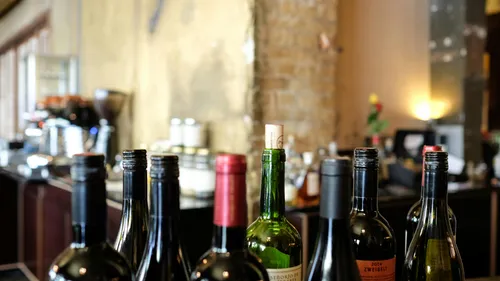 Wine bottles on countertop in a bar.