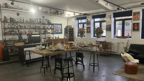 Bar setup with stools, bottles, and plants.