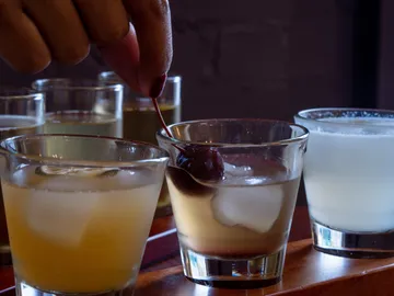 Ein Glas mit Eis werden mit einer Kirsche verziert.