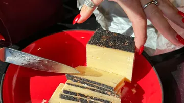 Messer zum Schneiden von Käse mit Schwarte auf dem Teller.