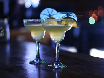 Zwei Cocktails stehen auf einem Tisch in einer Bar.