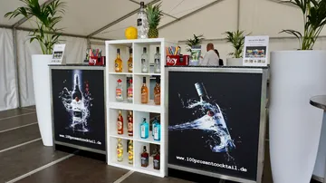 Barbestuhlung mit Spirituosenflaschen und tropischem Dekor.