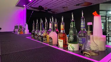 Liquor bottles lined up on bar counter.