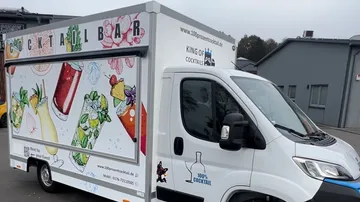 Cocktailbar-Truck mit farbenfrohen Bildern von Getränken.