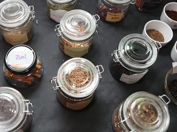 Jars with spices are placed on a black table.