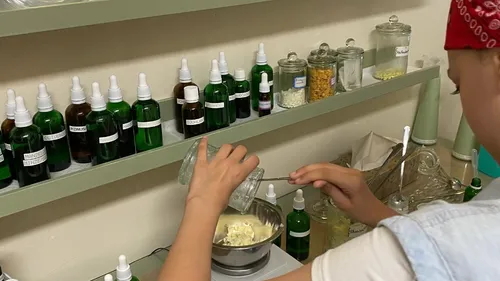 Person mixing ingredients in a lab setting.