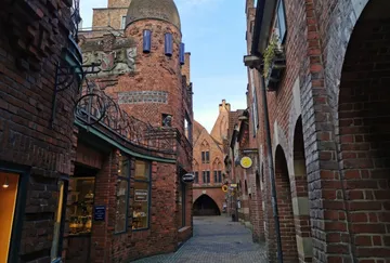 Enge Kopfsteinpflastergasse mit Backsteingebäuden.