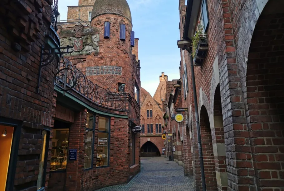 Enge Kopfsteinpflastergasse mit Backsteingebäuden.