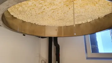 Großes Käsefass mit Quark in einer Molkerei.