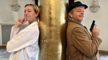 Two people stand back-to-back, posing confidently.
