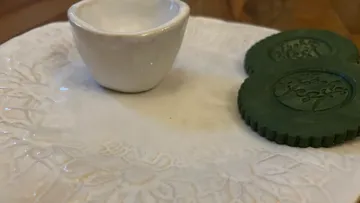Green cookies and cup on plate.