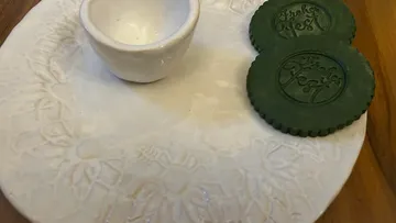 Ceramic plate with small bowl and two green cookies.