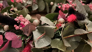 Floral wreath with eucalyptus leaves and pink accents.