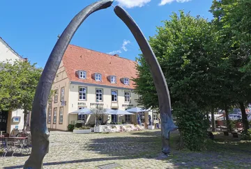 Whale bone arch in front of hotel building.