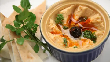 Schüssel Hummus mit Pita und Oliven.