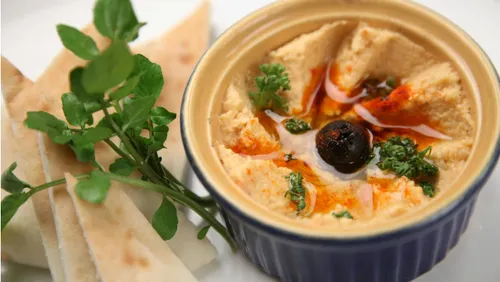 Schüssel Hummus mit Pita und Oliven.