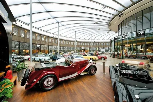 Vintage cars displayed in a glass-domed showroom.