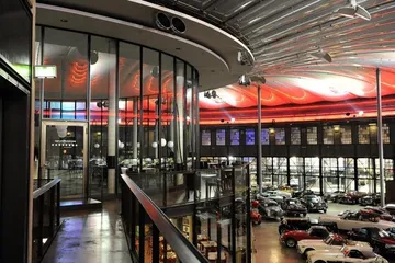 Innenraum des Oldtimer-Museums mit rot beleuchteter Decke.