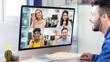 Person video calling four others on computer.