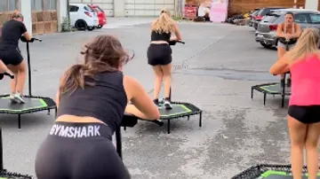 Women exercising on trampolines outdoors.