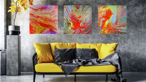 Colorful abstract paintings above yellow sofa.