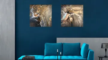 Abstract art above teal sofa in modern room.