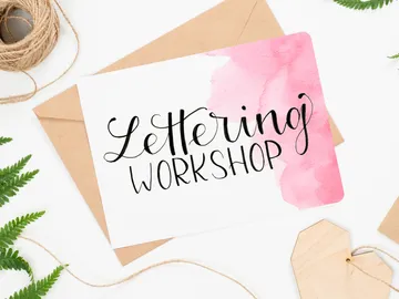 Card with the text `Lettering Workshop` on a table.