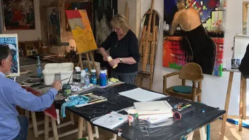 Two people painting in an art studio.