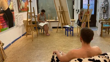 Artists sketching in a studio with life model.