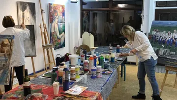 Two women painting in an art studio.