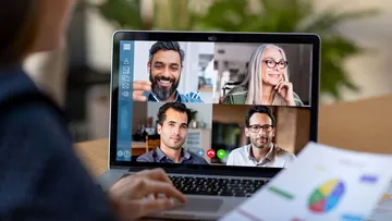 Person video conferencing on laptop with four people.